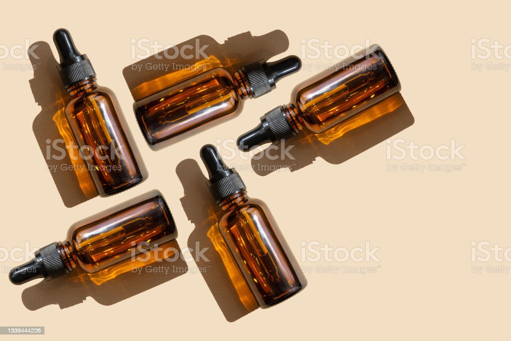Mock up of dropper bottles are arranged in chaotic order on beige background